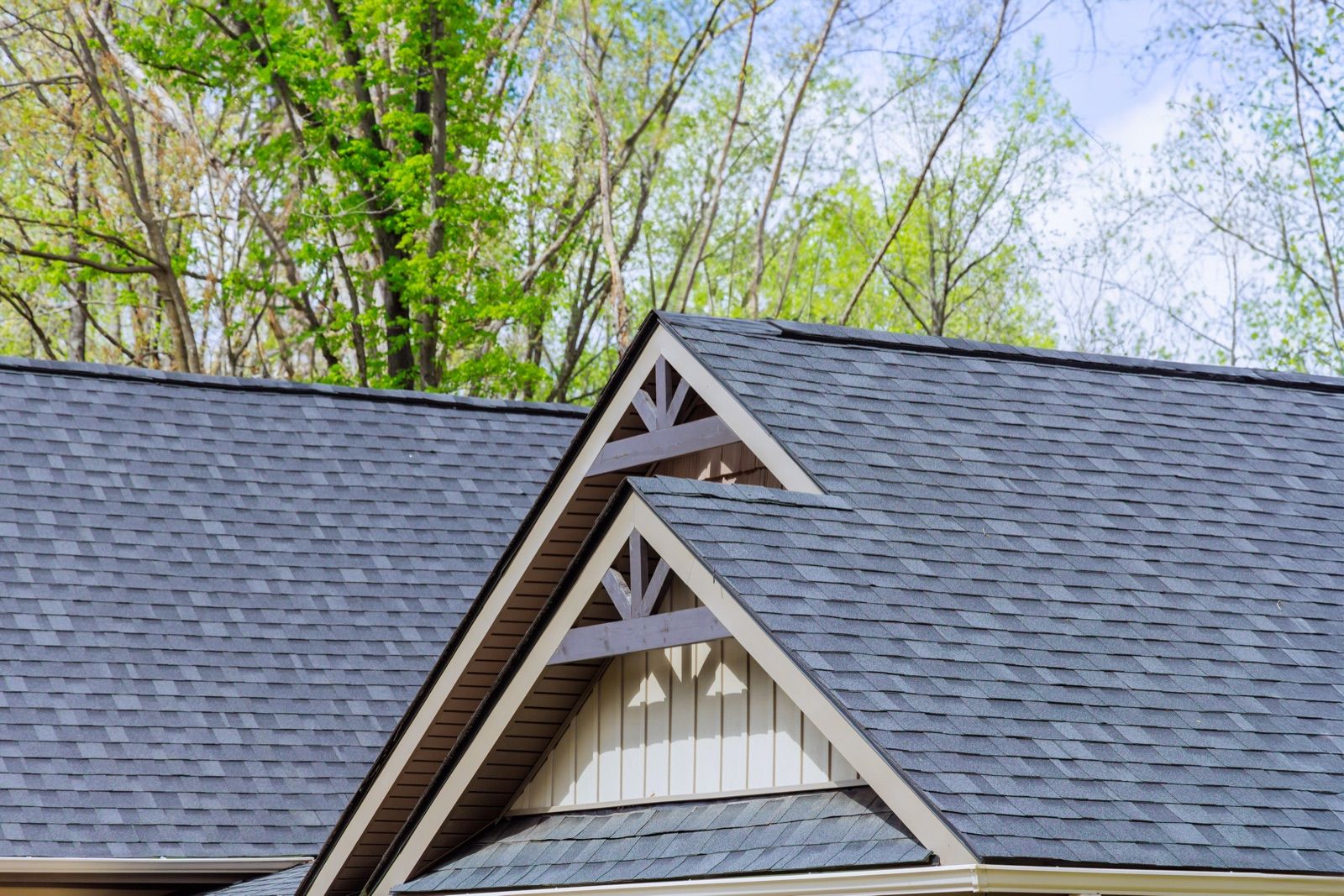 New asphalt shingles across the gables of a suburban house